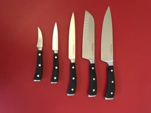 set of sharpened kitchen knives on a red background