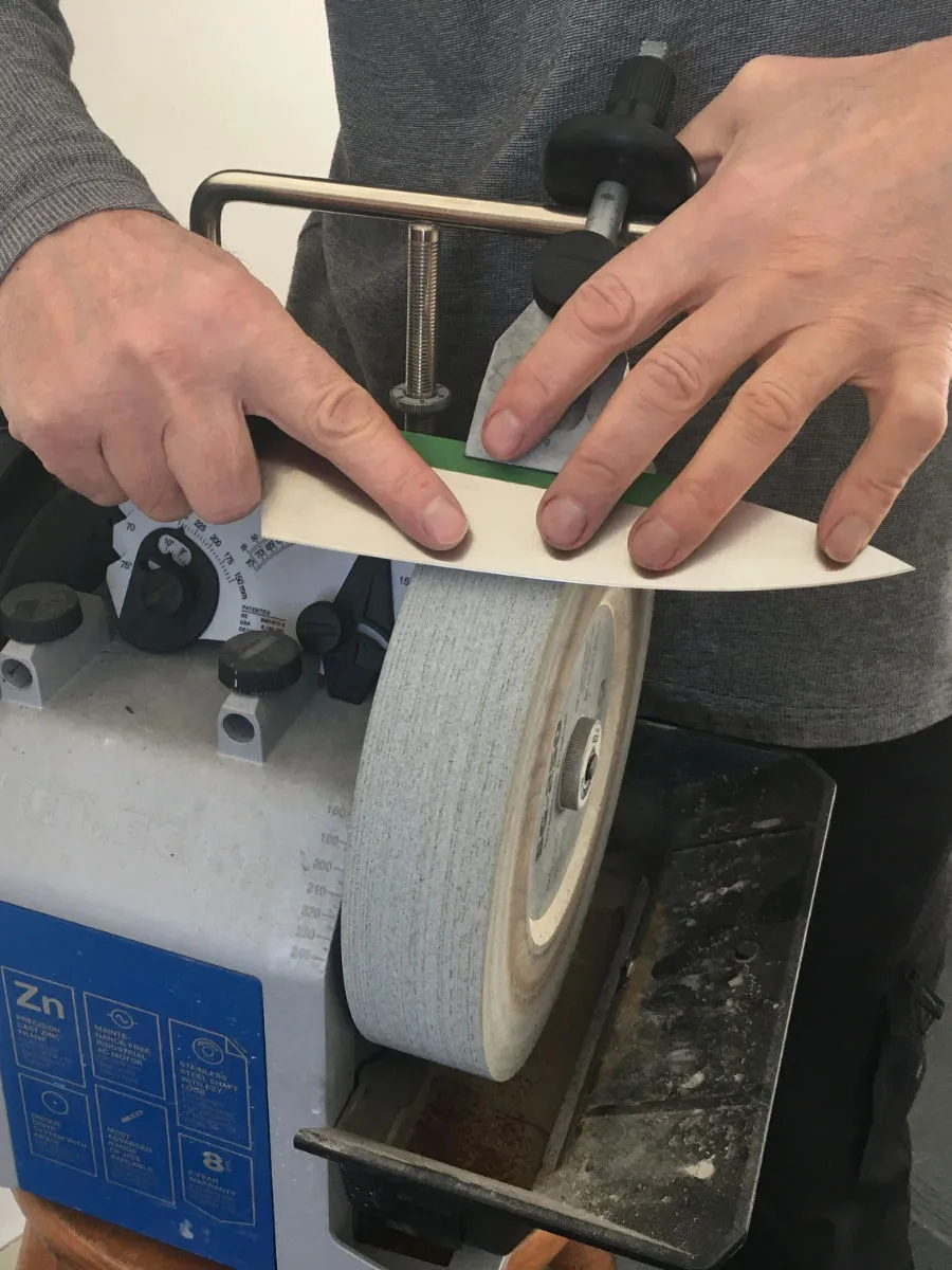 Man sharpening a chef knife on a precision guided system called a Tormek